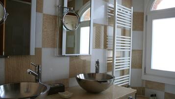 A bathroom with two sinks, a mirror, and a towel rack.
