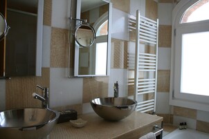 A bathroom with two sinks, a mirror, and a towel rack.
