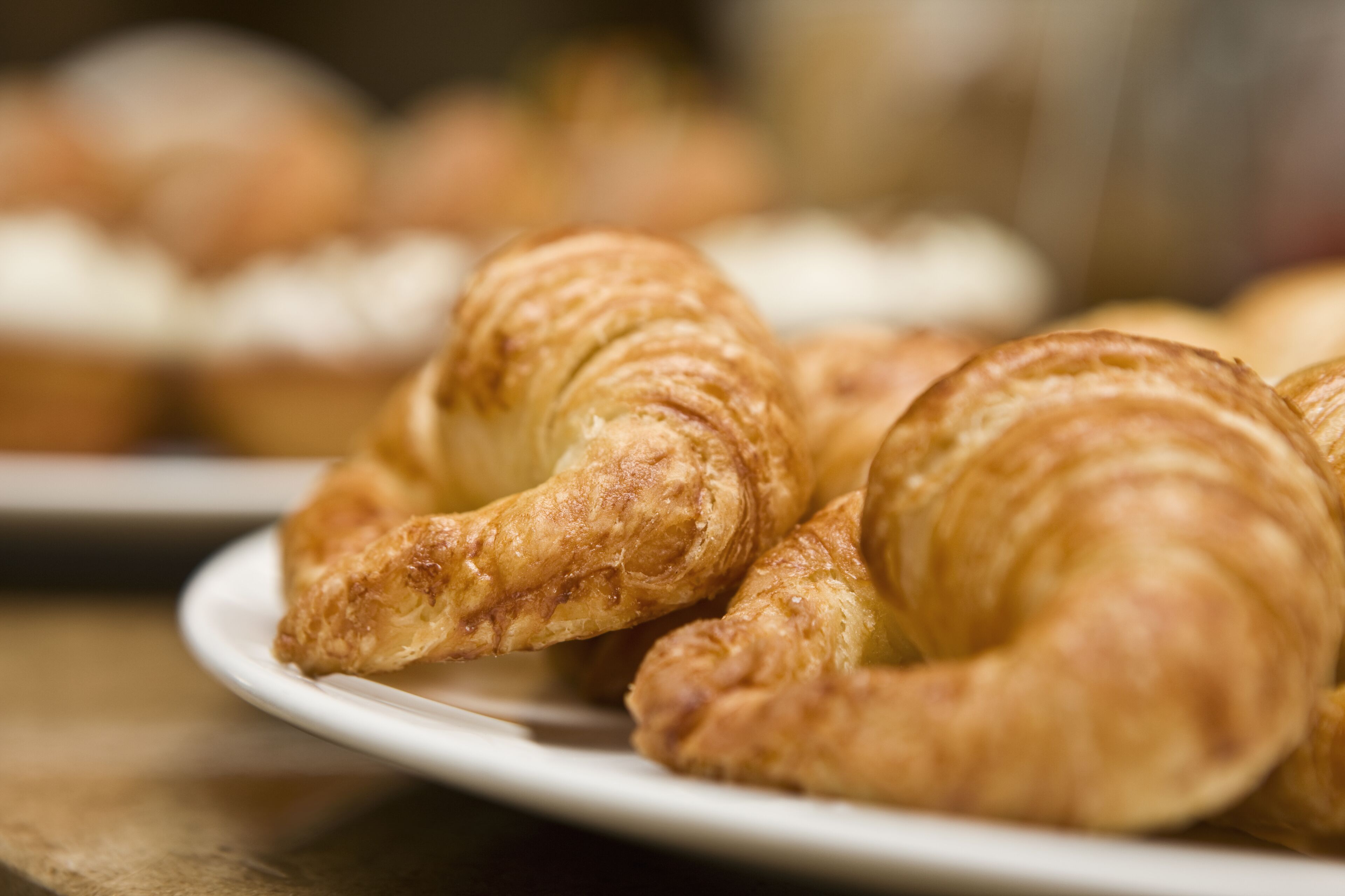 Une assiette de croissants sur une table.