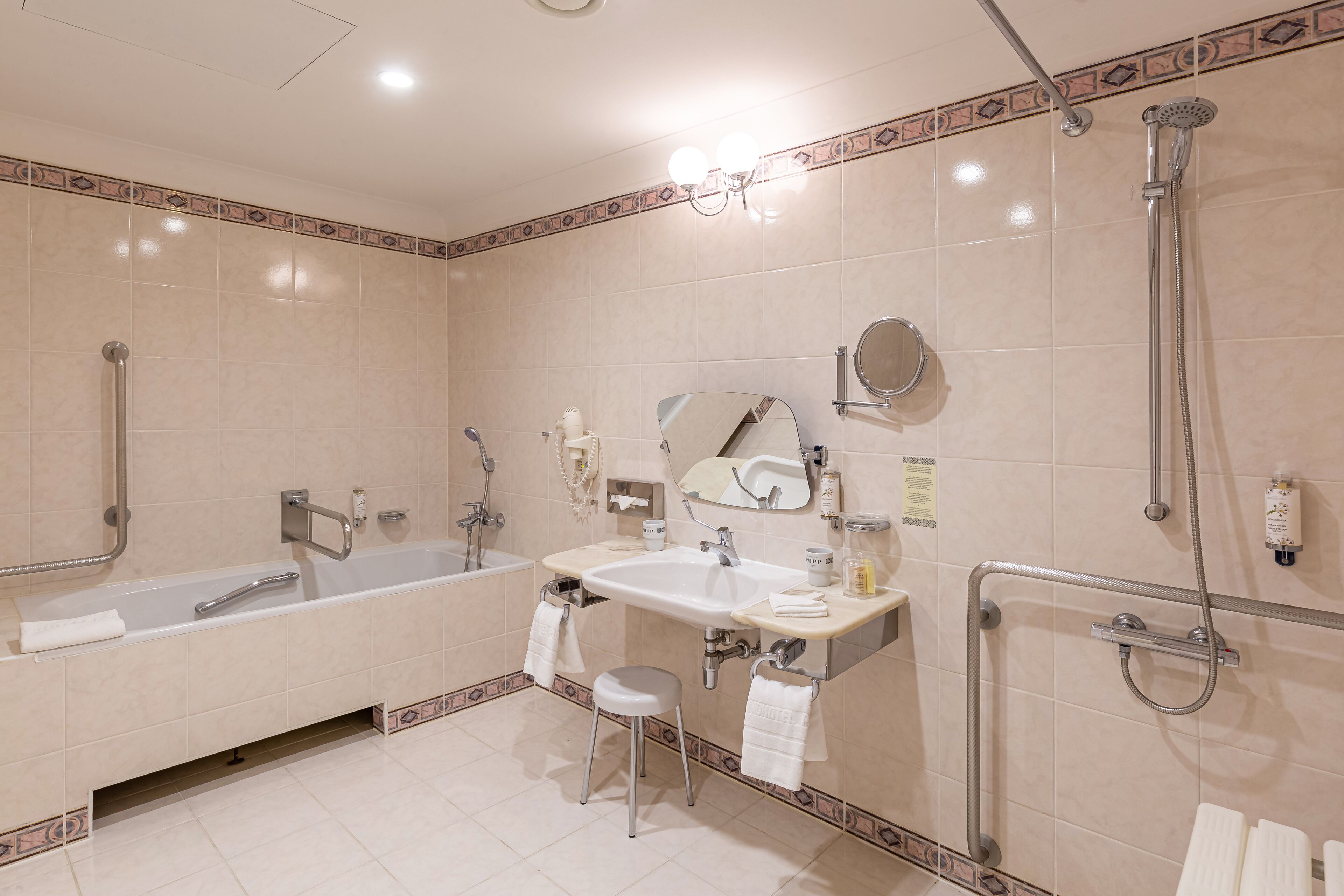 A modern bathroom with a bathtub, a sink, a mirror, and a shower.