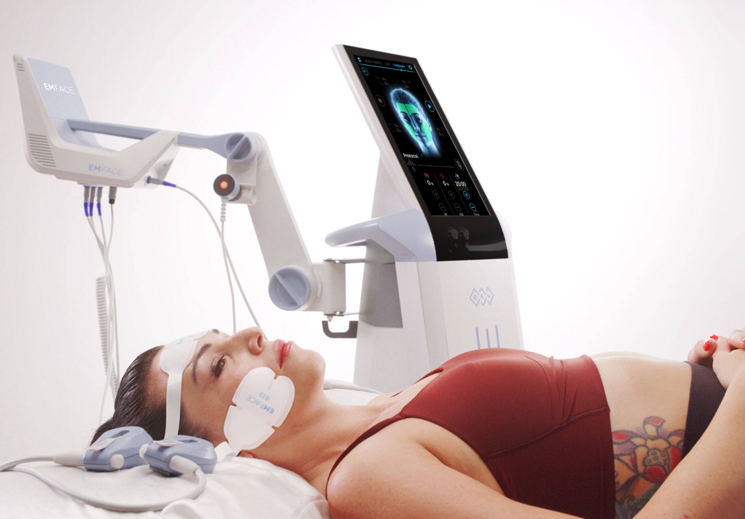 A medical device with a screen and a patient lying on a bed.