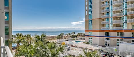A high-rise hotel with a view of the beach and ocean.
