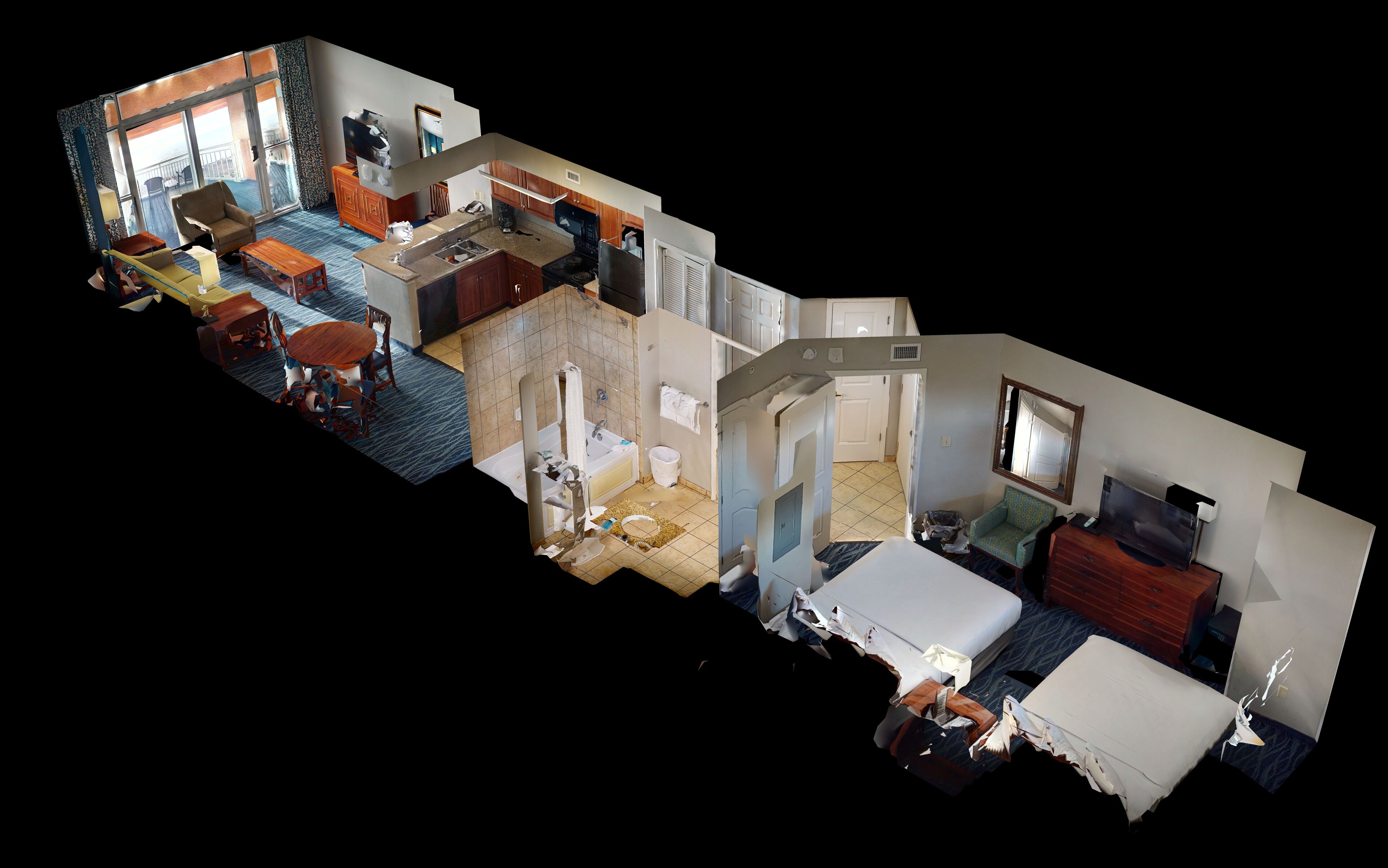 A hotel room with a balcony, a kitchenette, a bathroom, and a bed.