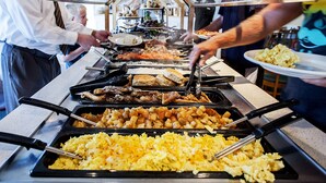 Un buffet proposant une variété de plats, notamment des œufs brouillés, de la viande et des pommes de terre.