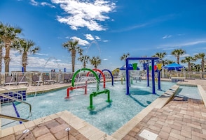 Una piscina con fuentes y palmeras.