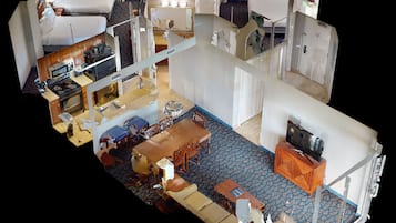 A hotel room with a bed, a desk, a television, a bathroom, and a dining area.