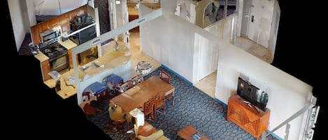 A hotel room with a bed, a desk, a television, a bathroom, and a dining area.