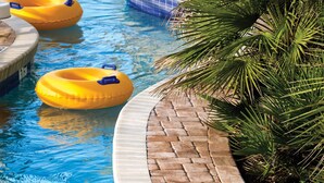 A swimming pool with multiple inflatable rings and a palm tree. - Club Wyndham Ocean Boulevard (North Myrtle Beach)