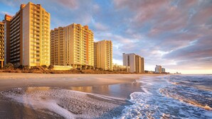 A beachfront hotel with multiple high-rise buildings, a sandy beach, and the ocean. - Club Wyndham Ocean Boulevard (North Myrtle Beach)