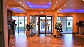 A hotel entrance with a brick floor, glass doors, and potted plants. - Quality Inn Rawlins I-80 (Rawlins)