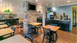 A restaurant with stone walls, wooden tables, and chairs. - Quality Inn Rawlins I-80 (Rawlins)