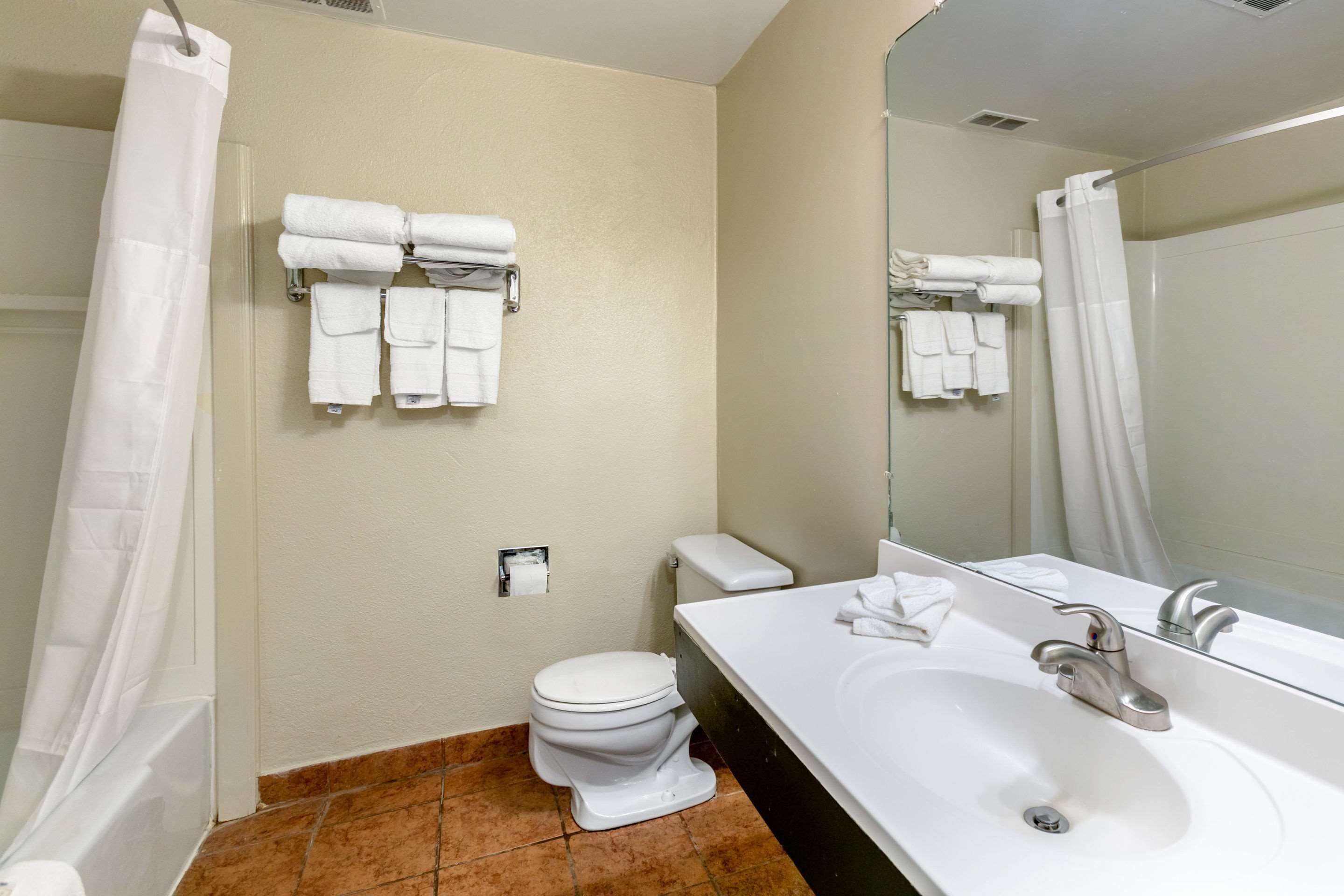Un baño con inodoro, lavabo y perchero para toallas.