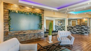A lobby with a stone wall, a reception desk, and seating areas. - Quality Inn Rawlins I-80 (Rawlins)
