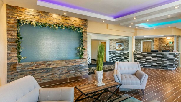 A lobby with a stone wall, a reception desk, and seating areas. - Quality Inn Rawlins I-80 (Rawlins)