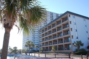 A multi-story hotel with balconies, a pool area, and palm trees. - Myrtle Beach Resort by Beach Vacations (Myrtle Beach)
