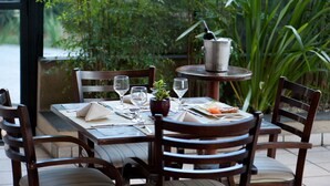 A dining table set with plates, glasses, cutlery, and a small potted plant. - HB Hotels Sequóia Alphaville (Barueri)