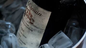 Uma garrafa de vinho Romantín em um balde de metal com cubos de gelo.
