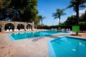 Una piscina al aire libre, sombrillas