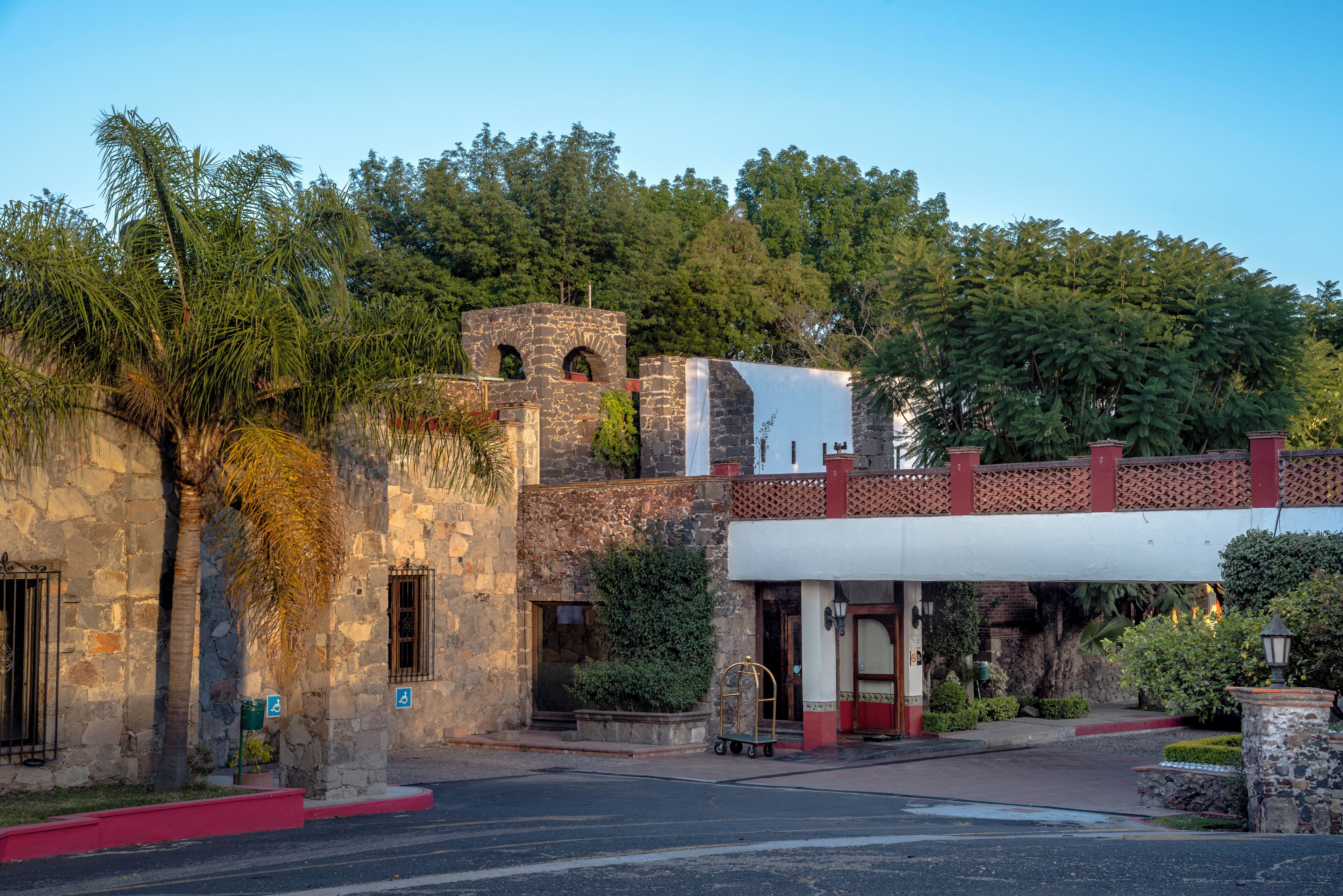 A historic building with stone walls, a small tower, and a covered entrance.