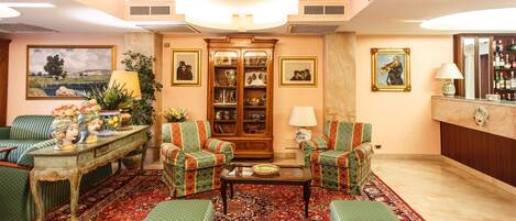 A traditional living room with a sofa set, a coffee table, a patterned rug, and a cabinet with glass doors.