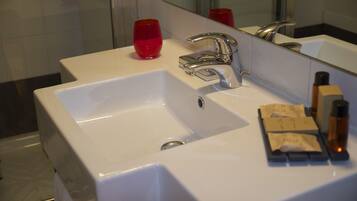 A bathroom sink with a mirror, a red cup, and toiletries.