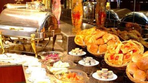 Un buffet proposant une variété de plats et un espace où l’on peut se servir soi-même pour les boissons.