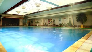 Une piscine intérieure dotée d’un plafond transparent et de lucarnes.
