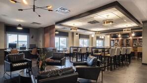 A modern lounge area with leather sofas, dining tables, and bar seating. - Four Points by Sheraton Louisville Airport (Louisville)