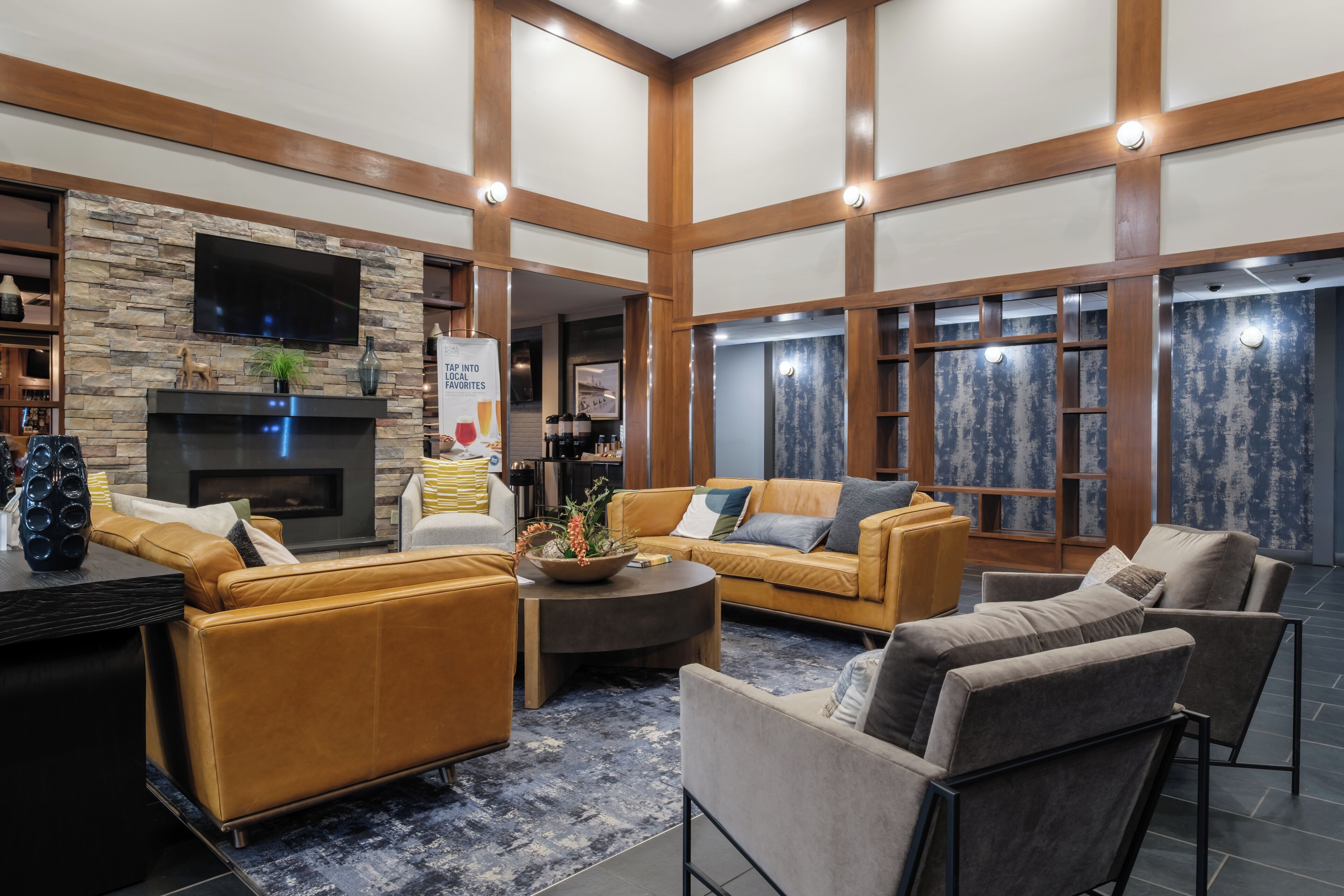 A spacious living area with a fireplace, comfortable seating, and a stone accent wall.