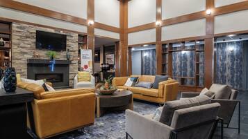 A spacious living area with a fireplace, comfortable seating, and a stone accent wall.