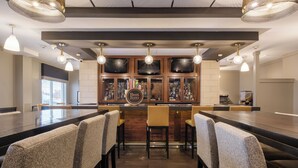 A bar area with a long counter, multiple bar stools, and a sign reading "Best Brews". - Four Points by Sheraton Louisville Airport (Louisville)