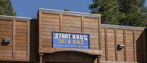A wooden building with a sign that reads "Start Haus Ski & Bike" offering ski tuning, boot service, and bike tuning.