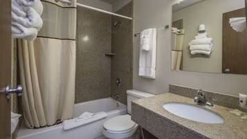 A bathroom with a bathtub, toilet, and sink.