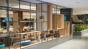 A modern interior with a glass partition, wooden shelves, and various decorative items. - Melia Castelo Branco (Castelo Branco)