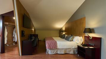 Una habitación de hotel con una cama, mesita de noche, lámpara y un escritorio con silla.