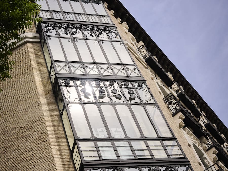 Un bâtiment doté de grandes fenêtres et de balcons en métal à motifs décoratifs.