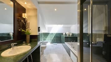 Un baño moderno con un espejo grande, un lavamanos, una bañera y una ducha.