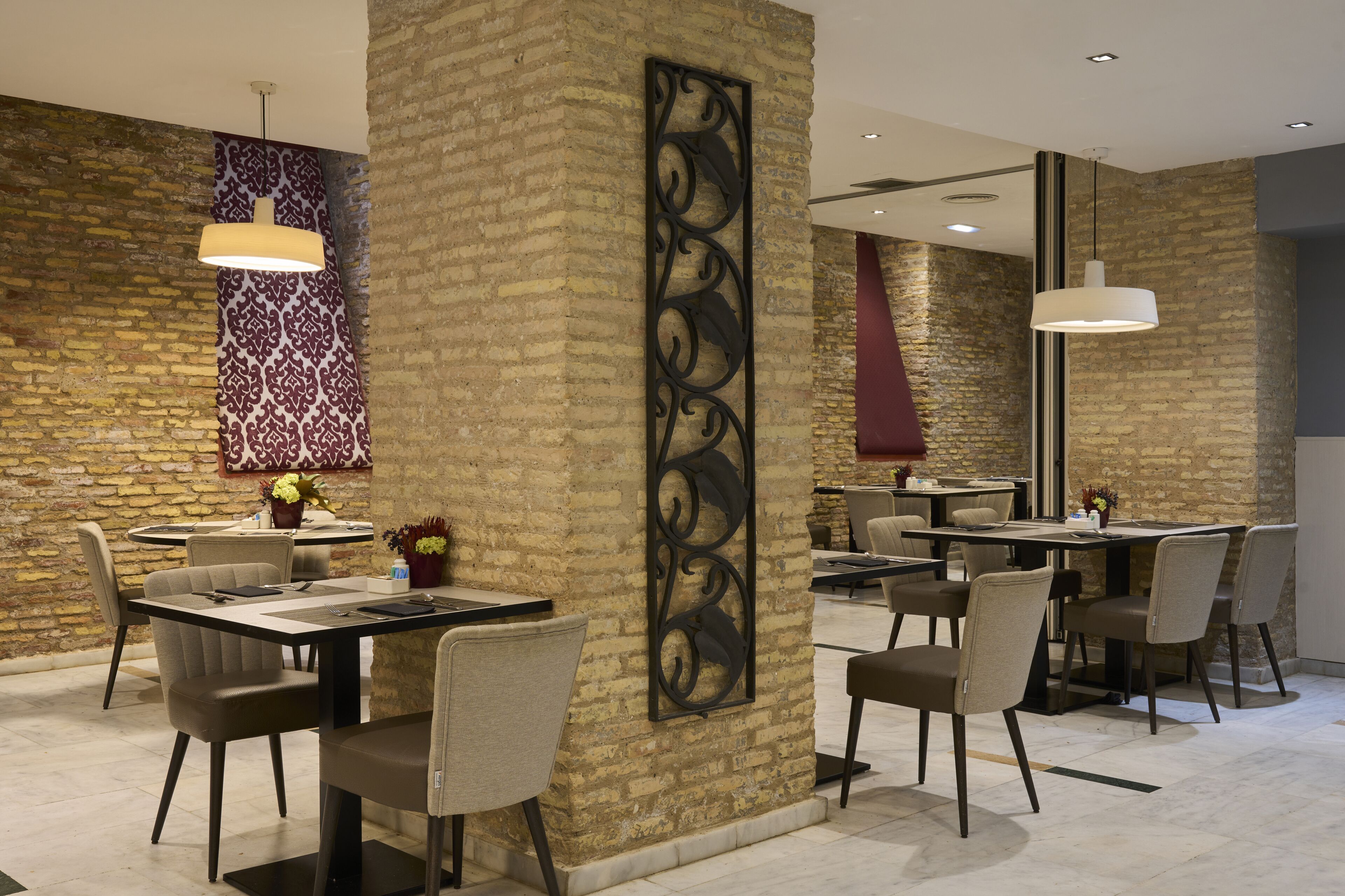 Un comedor moderno con paredes de ladrillo, muebles contemporáneos y decoración en la pared.