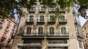 A historic building with a classic facade, multiple balconies, and a ground-level entrance. - Catalonia El Pilar (Zaragoza)
