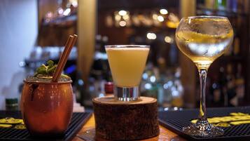 A bar setting with a traditional drink in a copper pot, a cocktail in a martini glass, and a glass of white wine.