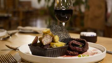 Un plato de comida con una copa de vino tinto.
