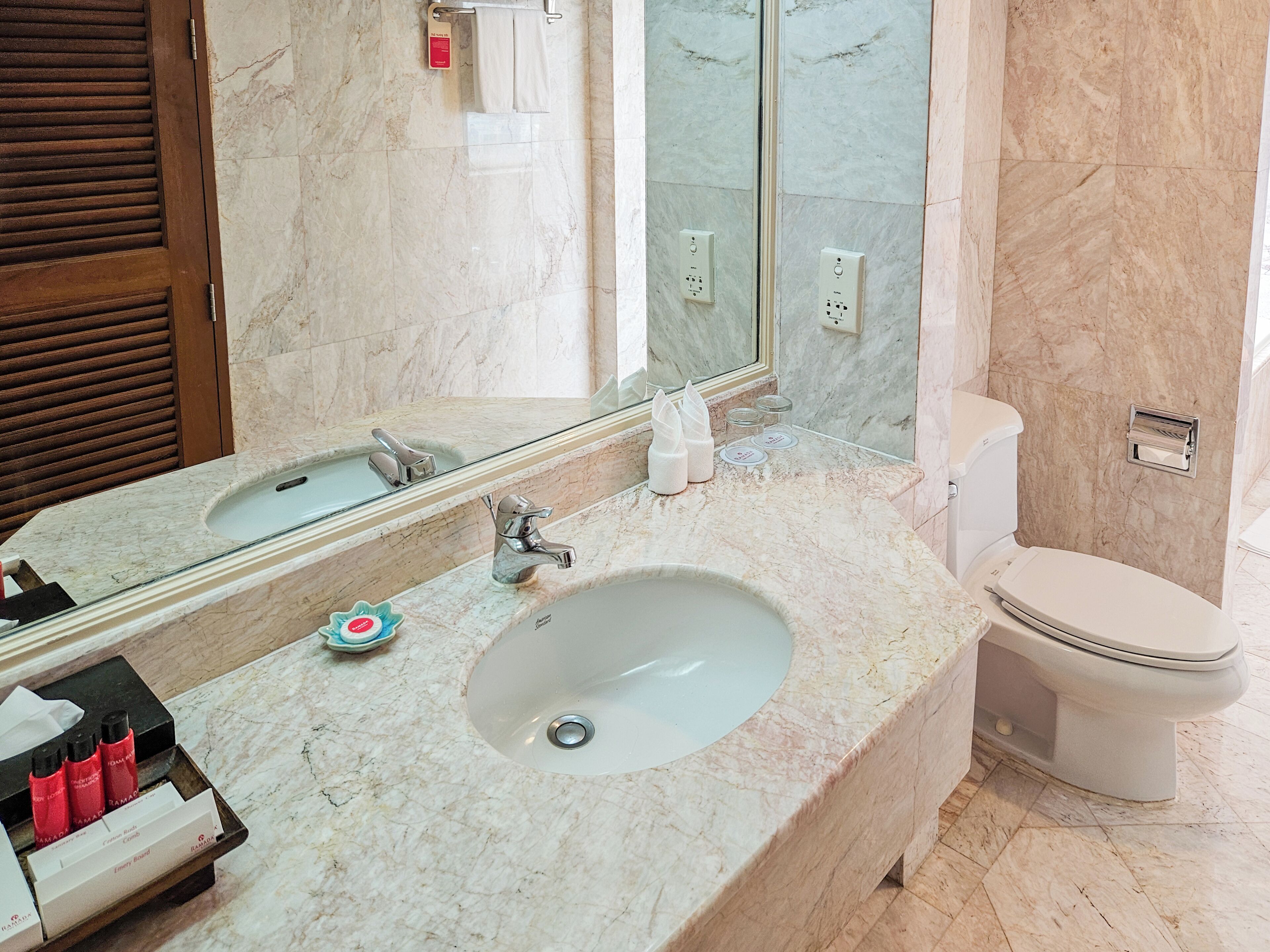 Un baño con dos lavamanos, un inodoro y un espejo grande.