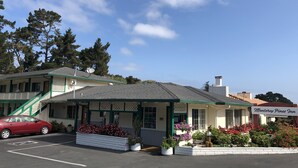 A two-story motel with a green and white exterior, a covered front porch, and a parking lot.