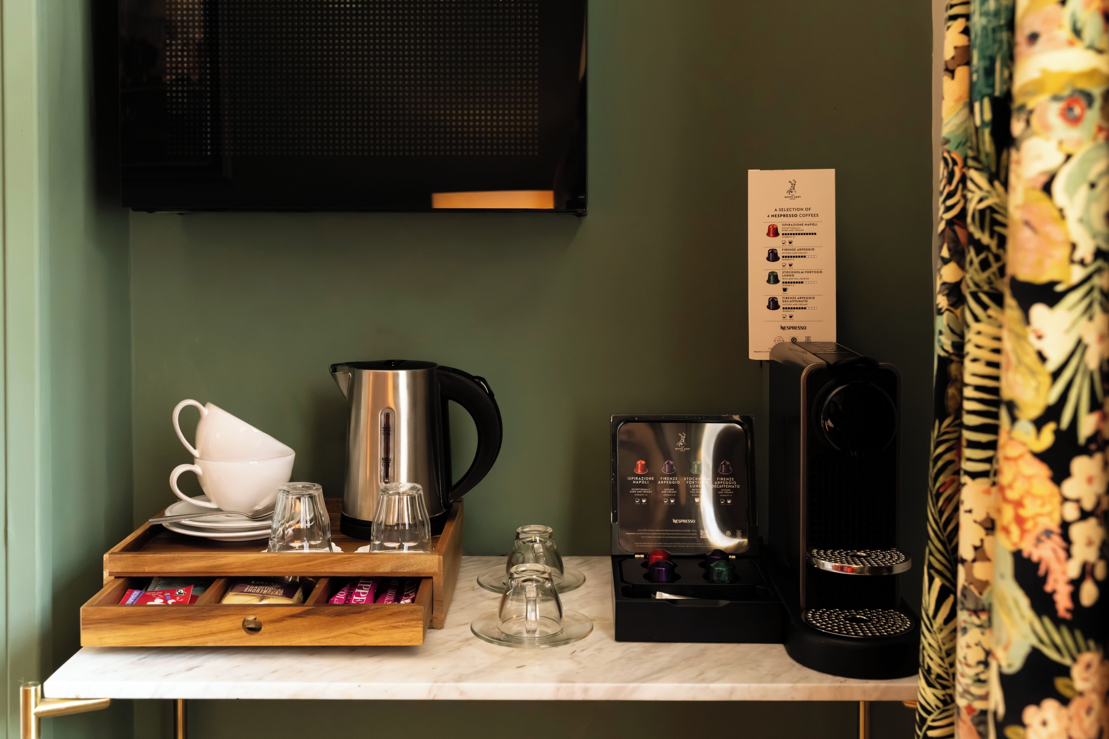 Un coin café équipé d’une machine à café, de tasses et d’un menu.