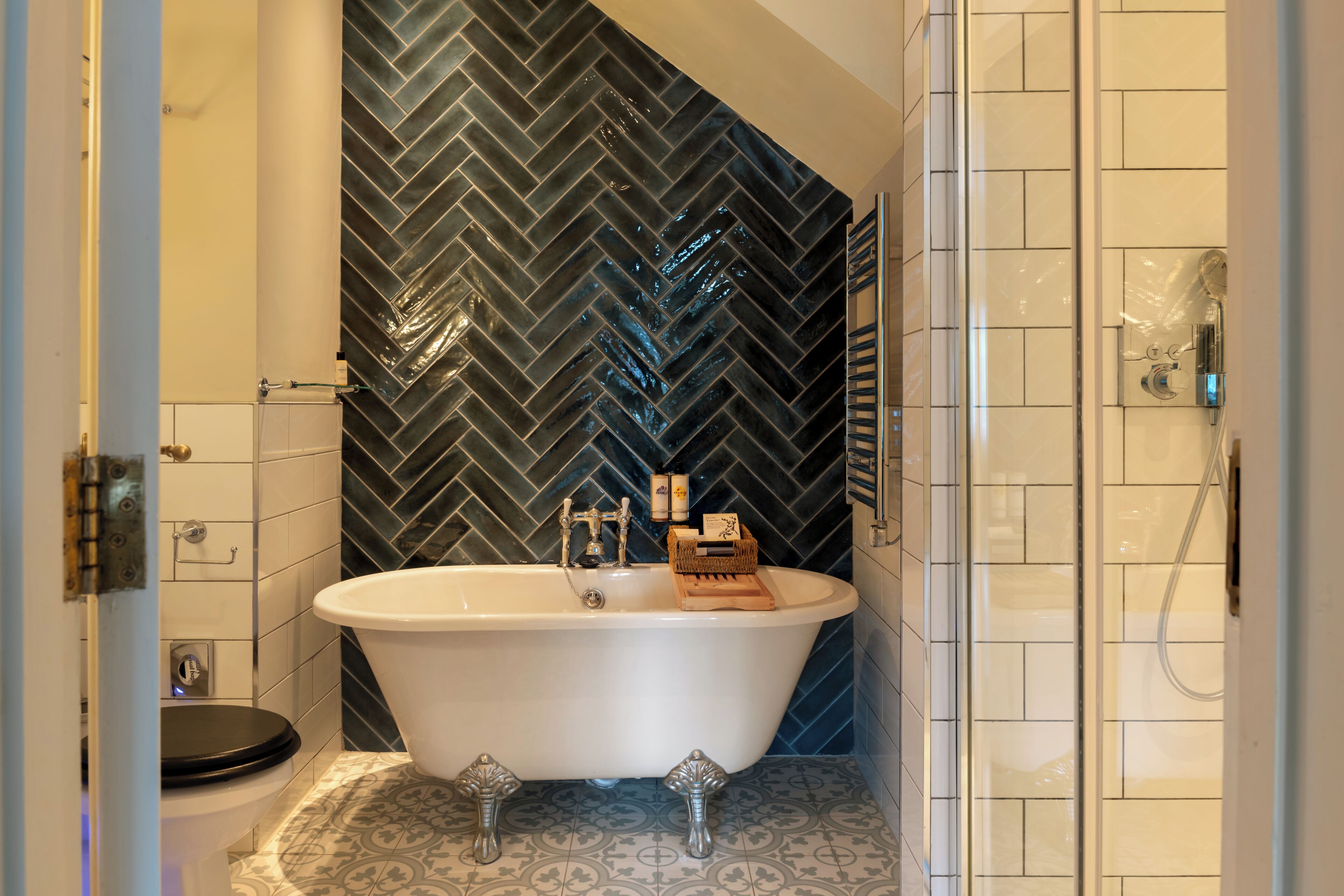 Une salle de bain comprenant une baignoire sur pieds, des toilettes et un espace douche.