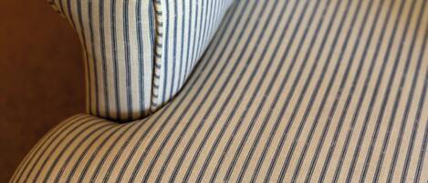 A striped sofa with a curved backrest and armrests.