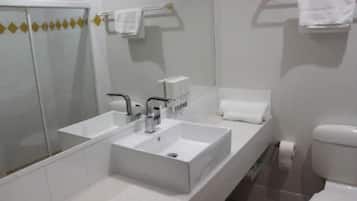 Une salle de bain moderne avec un grand miroir, un double vasque et des toilettes.