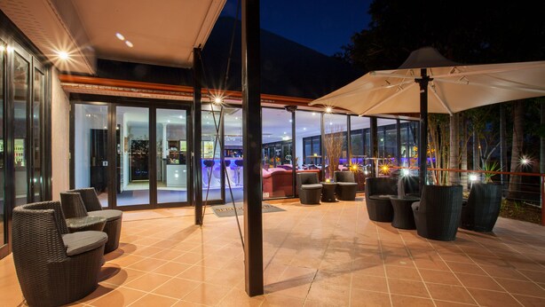 Un patio al aire libre con asientos, una zona cubierta y vistas del interior.