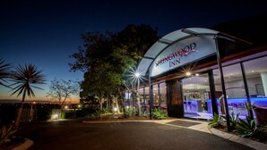 Entrada de un hotel con un letrero que dice 'Springwood Inn'.