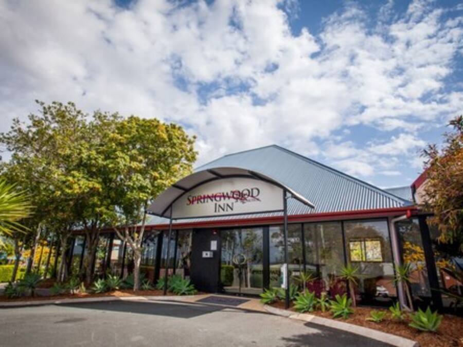 A Springwood Inn with a modern design, featuring a covered entrance and a landscaped garden.